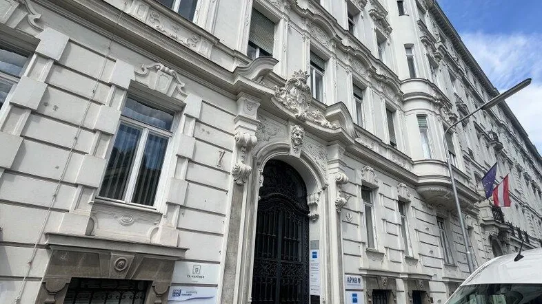Klassische Fassade eines historischen Gebäudes mit aufwendigen Verzierungen und großen Fenstern.