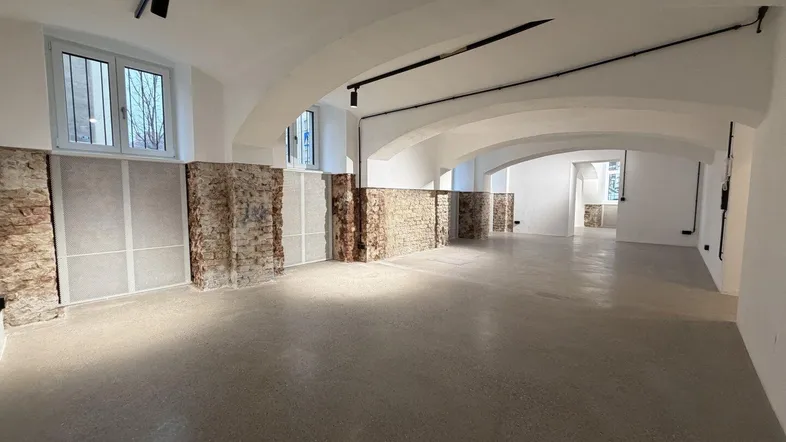 Geräumiger, leerer Raum mit Gewölbedecken, freigelegten Ziegelwänden und Betonboden, ideal für Gewerbe.