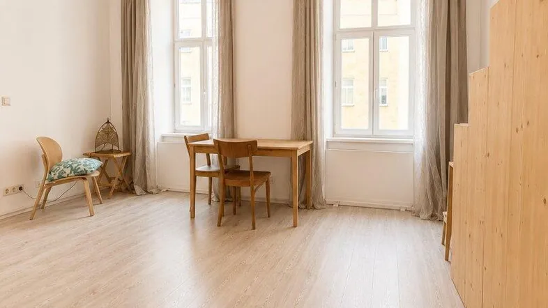 Heller Wohn- und Essbereich mit modernem Lichtkonzept, Holzboden und Blick auf die Stadt.