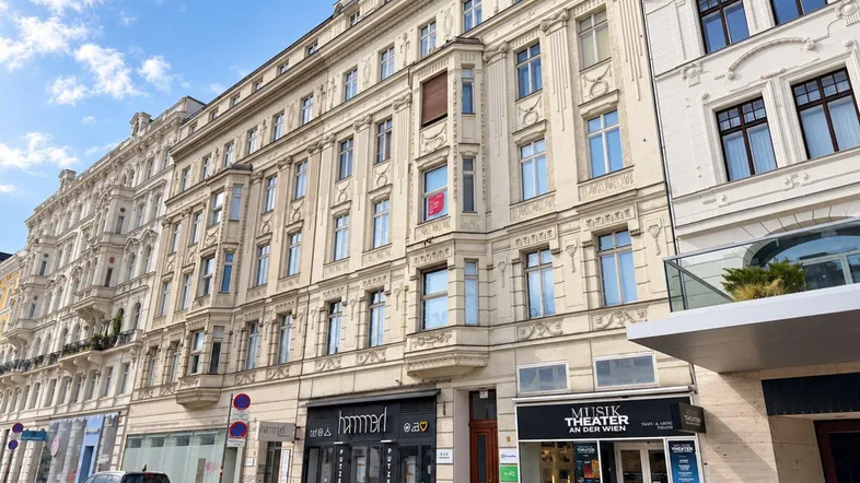 Klassisches Wiener Zinshaus mit Geschäften im Erdgeschoss und Wohnungen darüber, an einer belebten Straße gelegen.