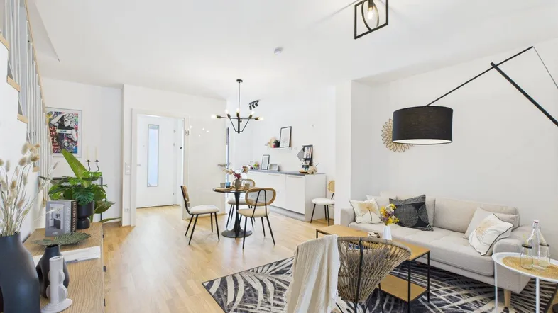 Helles, modern eingerichtetes Wohn- und Esszimmer mit Holzboden und stilvoller Dekoration.