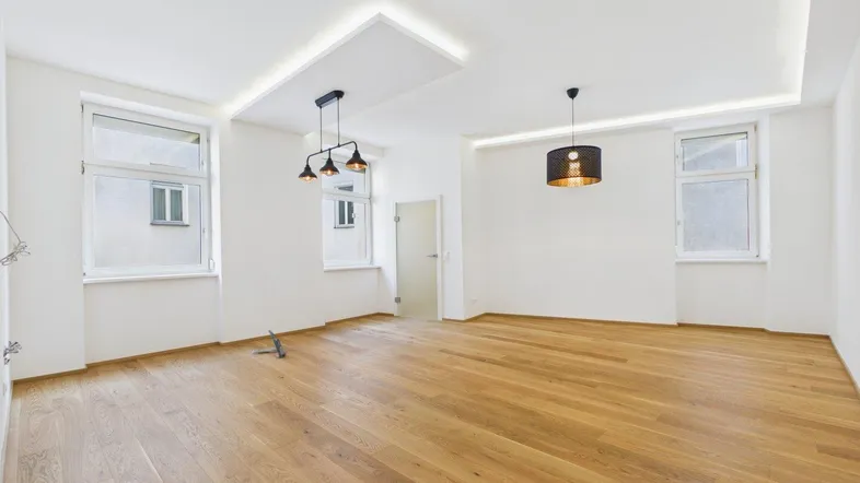 Helles, geräumiges Wohnzimmer mit modernem Parkettboden und stilvollen Deckenleuchten.