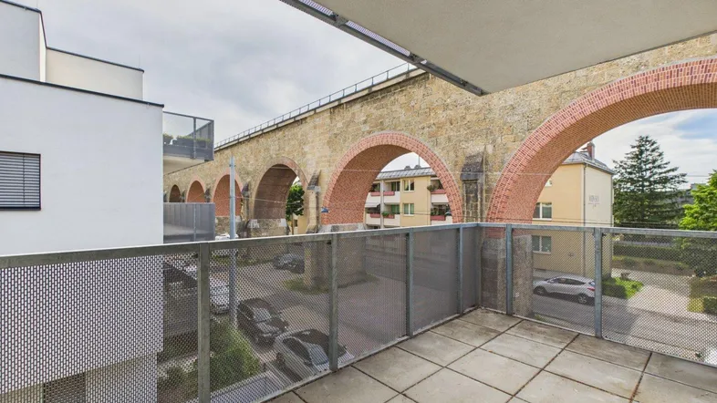 Balkon mit Blick auf eine historische Steinbrücke und die umliegende Nachbarschaft.