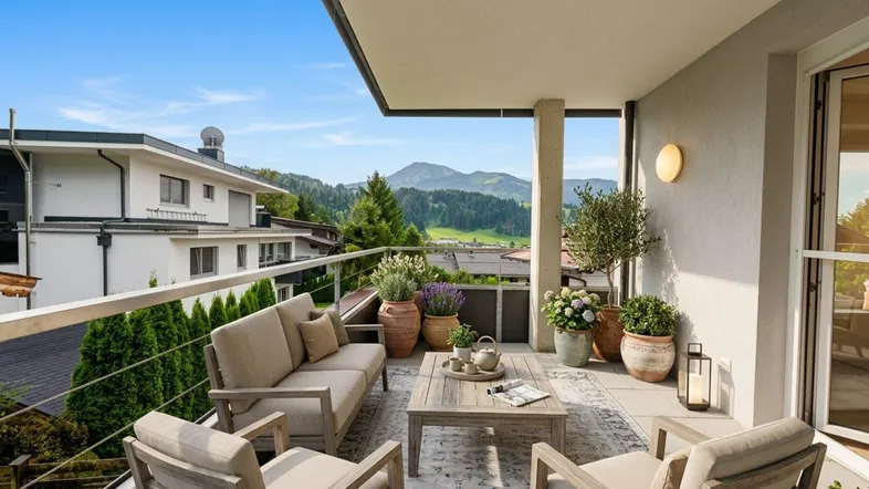 Geräumiger Balkon mit bequemen Gartenmöbeln und weitem Blick auf die umliegende Berglandschaft.