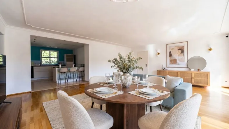 Helles Wohn- und Esszimmer mit modernem Esstisch und Blick auf die offene Küche.