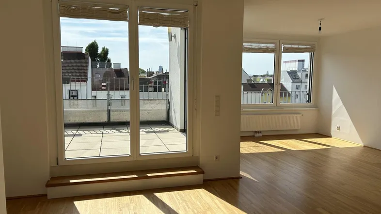 Helles Wohnzimmer mit Parkettboden, Zugang zur Terrasse und viel natürlichem Licht.