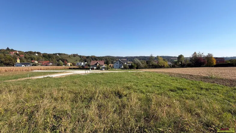 Weitläufiges Grundstück mit grüner Wiese und Blick auf die umliegende Landschaft und Häuser.