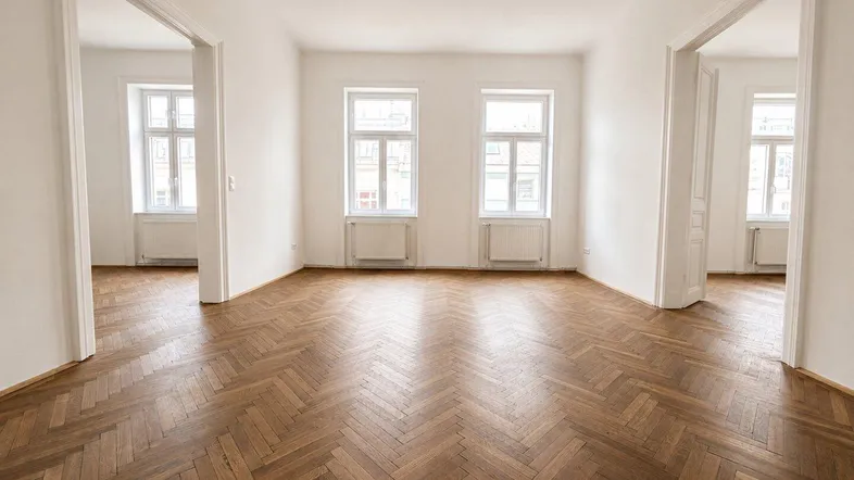 Helles Zimmer mit Fischgrätparkett und hohen Decken, bereit zur individuellen Gestaltung.