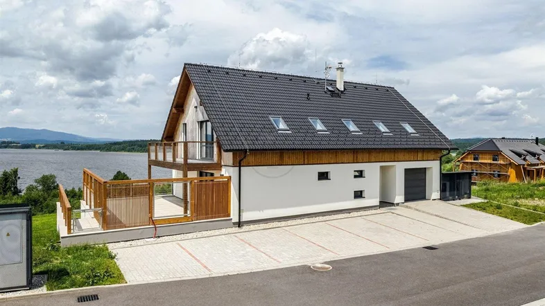 Modernes Haus mit Seeblick, großzügiger Terrasse und integrierter Garage.