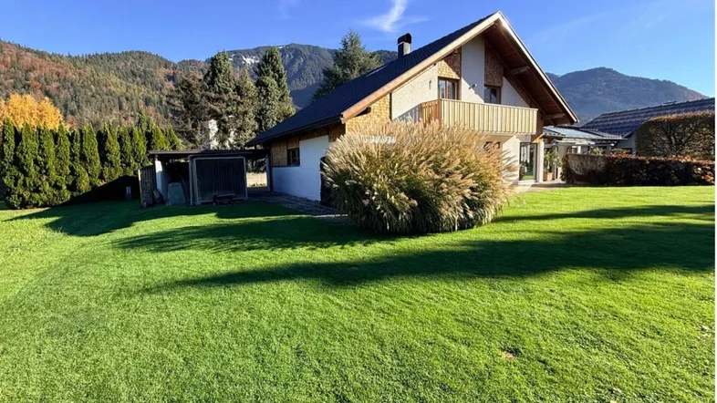 Gepflegtes Einfamilienhaus mit großem Garten, Balkon und Bergblick in ländlicher Umgebung.