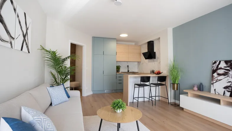 Helles Wohnzimmer mit offener Küche, Holzboden und modernem Design.
