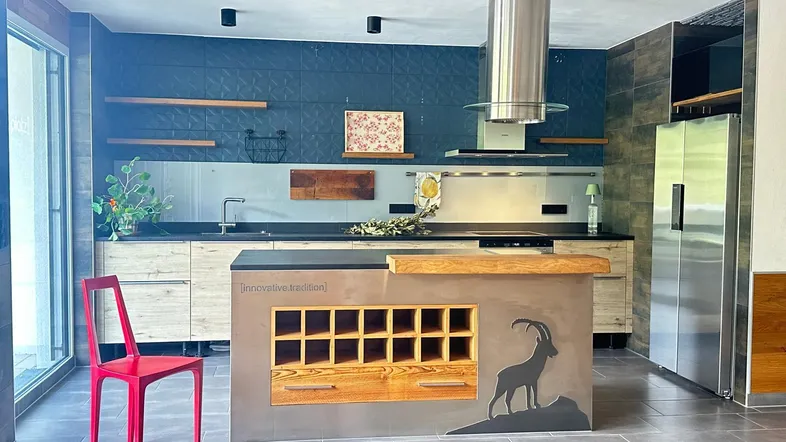 Moderne Küche mit Kücheninsel, Holzelementen und Edelstahlgeräten, ideal für geselliges Kochen.