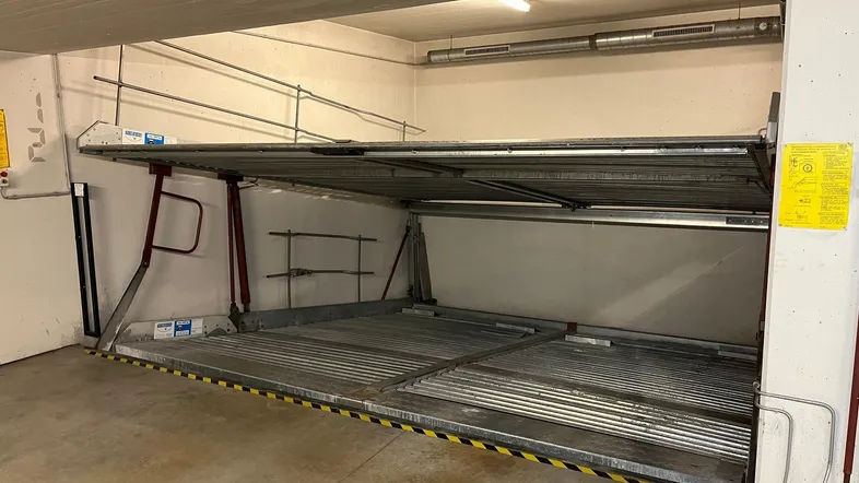 Mechanisches Doppelparkersystem in einer Tiefgarage, bereit zur Aufnahme von zwei Fahrzeugen.