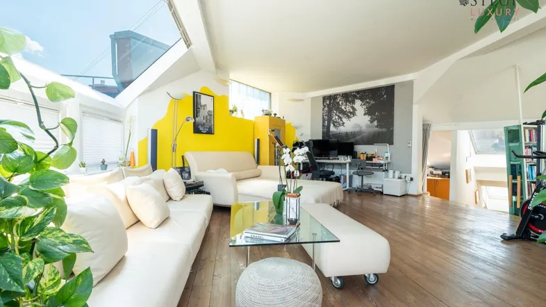 Helles und offenes Wohnzimmer mit Holzboden, großen Fenstern und modernem Design.