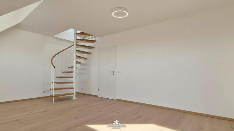 Heller Raum mit Holzfußboden, Wendeltreppe und Dachschrägen, ideal für individuelle Gestaltung.