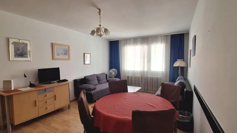 Geräumiges Wohnzimmer mit Essbereich, Sofa und einem Holztisch.