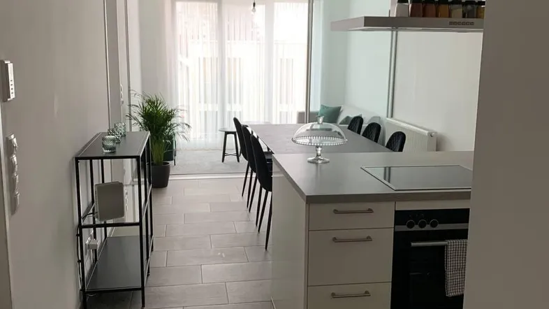 Moderne offene Küche mit Essbereich und Blick auf den angrenzenden Wohnbereich.