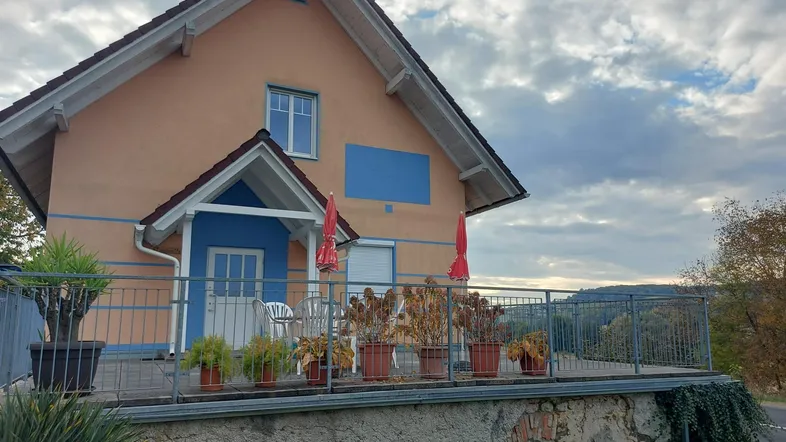 Großzügige Terrasse mit Metallgeländer und Blick auf die umliegende Landschaft, ideal für Entspannung im Freien.
