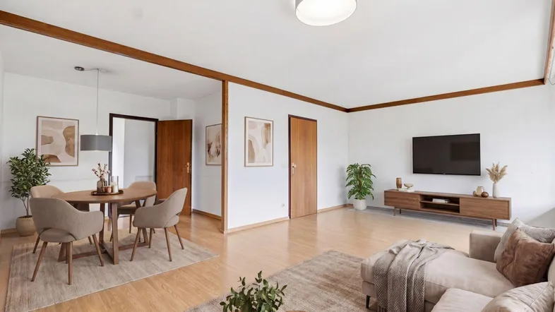 Helles Wohn- und Esszimmer mit Holzbalken, Parkettboden und moderner Einrichtung.