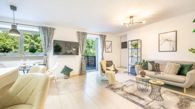 Helles Wohn- und Esszimmer mit modernen Möbeln, Fliesenboden und Zugang zum Balkon.