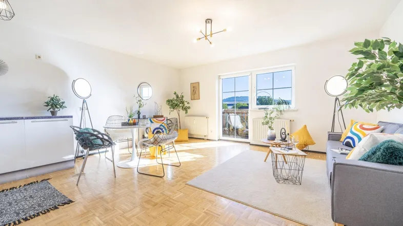 Helles Wohn- und Esszimmer mit Parkettboden, Balkonzugang und moderner Einrichtung.