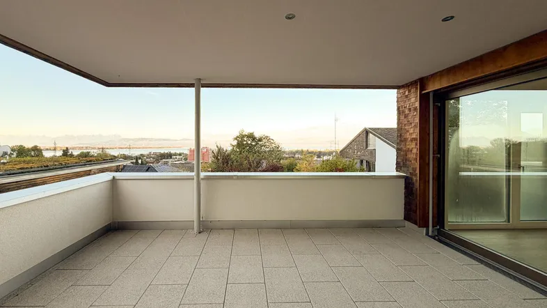 Große, geflieste Terrasse mit weitem Blick über die Dächer und den See.