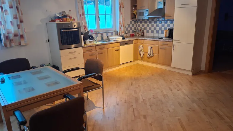 Geräumige Küche mit Holzelementen, Essbereich und Fenster, ideal für gemeinsame Mahlzeiten.