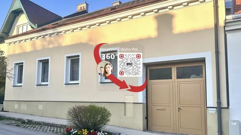 Hausfassade mit beige gestrichener Oberfläche und integrierter Garage, präsentiert sich in gutem Zustand.