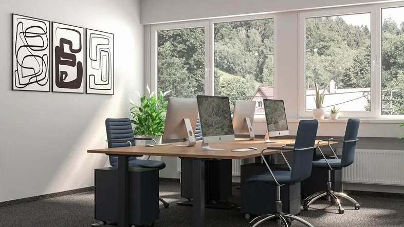 Modernes Büro mit mehreren Arbeitsplätzen, Computern und großen Fenstern mit Blick ins Grüne.