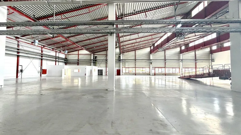 Geräumige, leere Lagerhalle mit hohen Decken und Betonboden, bereit für die Nutzung.
