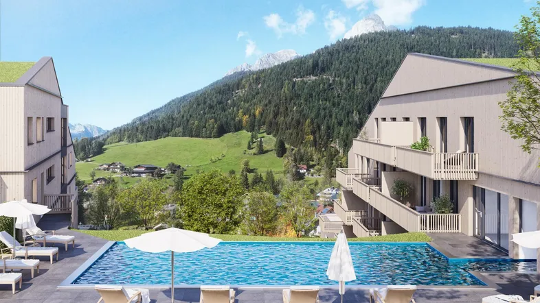 Außenpoolbereich mit Liegestühlen und beeindruckendem Blick auf die grüne Berglandschaft.