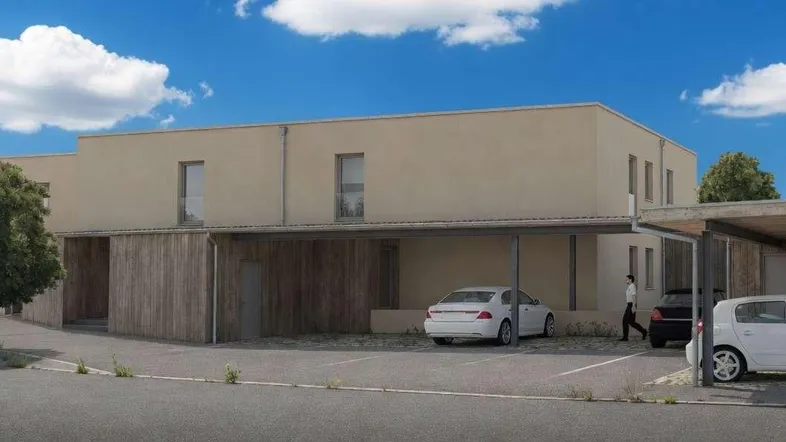 Moderne Wohnanlage mit Carports und schlichter Fassade unter blauem Himmel.