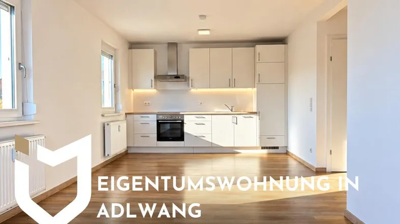 Helle, moderne Einbauküche mit weißen Fronten und integrierten Geräten in einem offenen Wohnbereich.