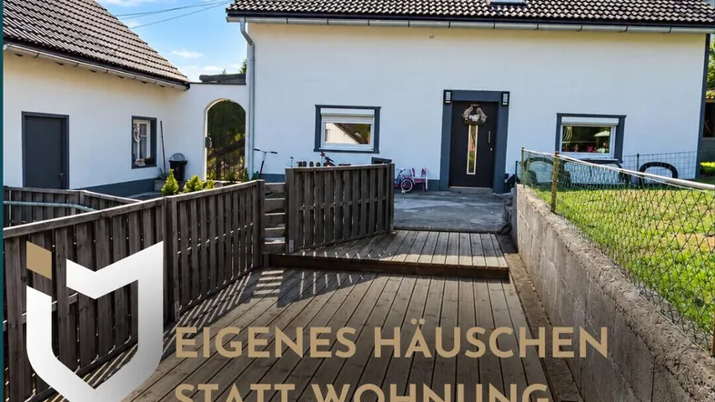 Geräumige Holzterrasse vor dem Einfamilienhaus mit Blick auf die Umgebung und viel Potenzial.