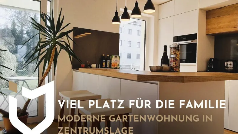 Moderne Küche mit Kochinsel, Holzarbeitsplatte und Zugang zum Gartenbereich.
