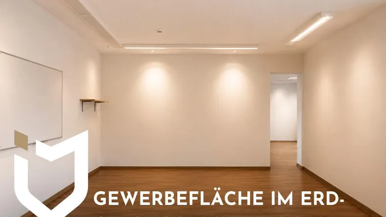 Heller, leerer Gewerberaum im Erdgeschoss mit modernen Deckenleuchten und Holzboden.
