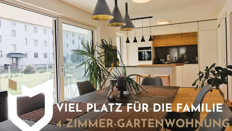 Moderner offener Wohn- und Essbereich mit integrierter Küche, großen Fenstern und Zugang zum Garten.