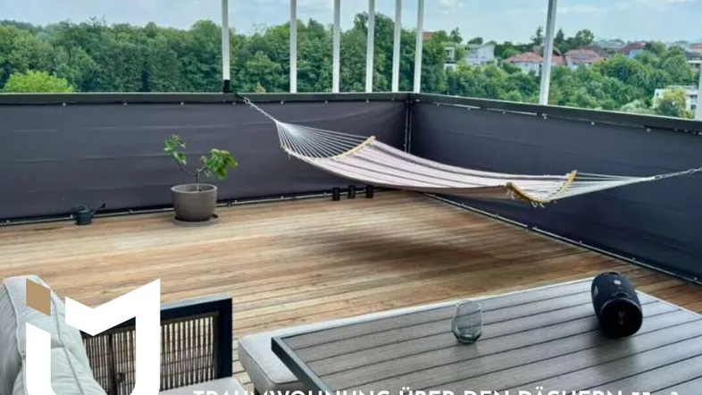 Dachterrasse mit Holzboden, Hängematte und Sitzbereich, ideal zum Entspannen über den Dächern.