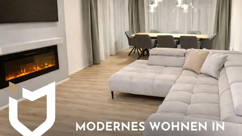 Moderner offener Wohn- und Essbereich mit Kamin, großem Sofa und hellem Laminatboden.