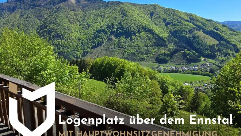 Panoramablick vom Balkon auf die grüne Berglandschaft und das malerische Ennstal unter strahlend blauem Himmel.