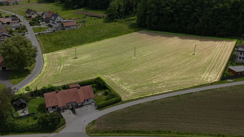 Luftaufnahme eines Anwesens mit Wohnhaus, Zufahrt und angrenzendem Feld, umgeben von Natur.