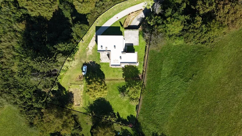 Luftaufnahme des Anwesens mit Wohnhaus, großem Grundstück und umgebender Natur.