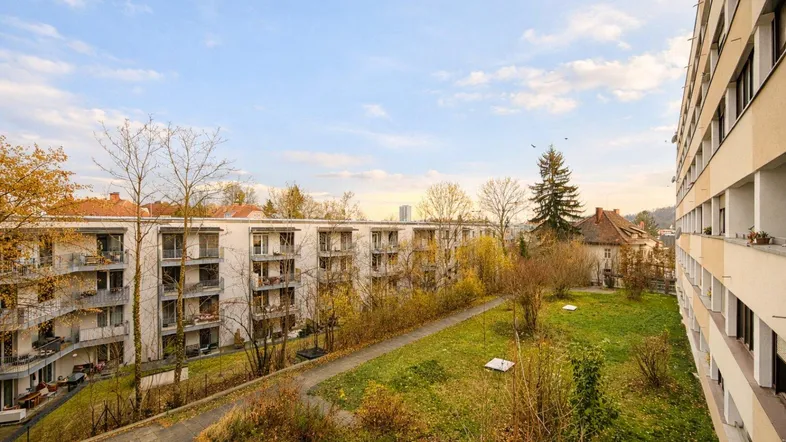 Blick auf die Wohnanlage mit mehreren Gebäuden und einer weitläufigen Grünfläche.