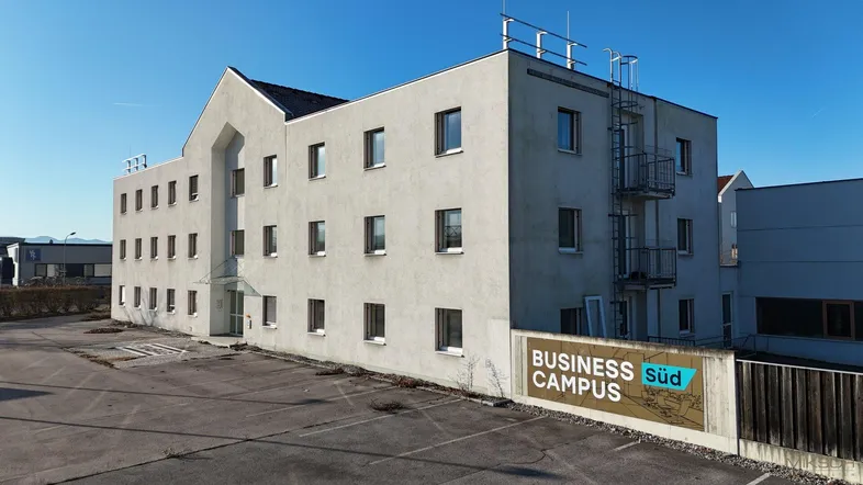 Modernes Geschäftsgebäude mit heller Fassade und einem "Business Süd Campus" Schild im Vordergrund.