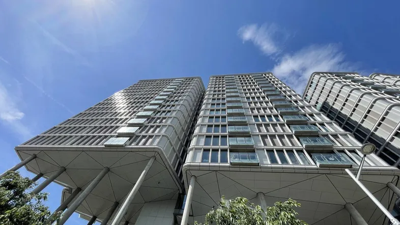 Moderne Hochhäuser mit einzigartiger Architektur und vielen Fenstern unter blauem Himmel.