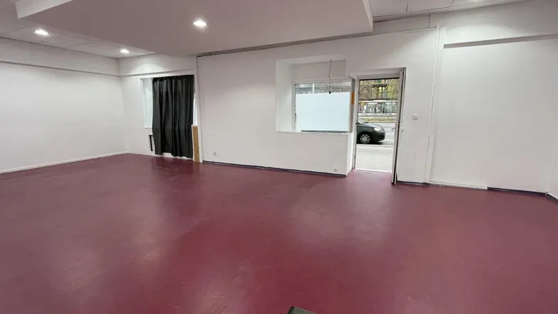 Geräumiger, leerer Gewerberaum mit direktem Zugang zur Straße und großen Fenstern, ideal für Einzelhandel oder Büro.