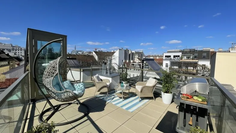 Geräumige Dachterrasse mit modernen Gartenmöbeln, Grillbereich und weitem Blick über die Stadt.