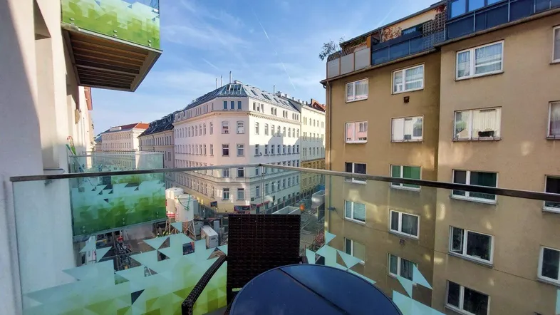 Balkon mit Glasbrüstung und Sitzgelegenheiten bietet einen weiten Blick auf die umliegende Stadt.