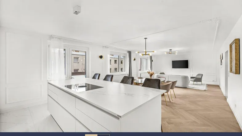 Heller offener Wohn- und Essbereich mit moderner Küche, Kochinsel und Zugang zum Balkon.