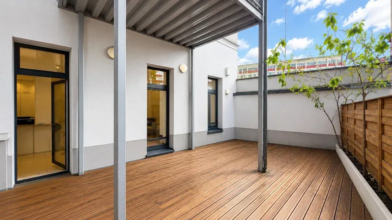 Geräumige Terrasse mit Holzboden und Zugang zu den Innenräumen, ideal für entspannte Stunden im Freien.